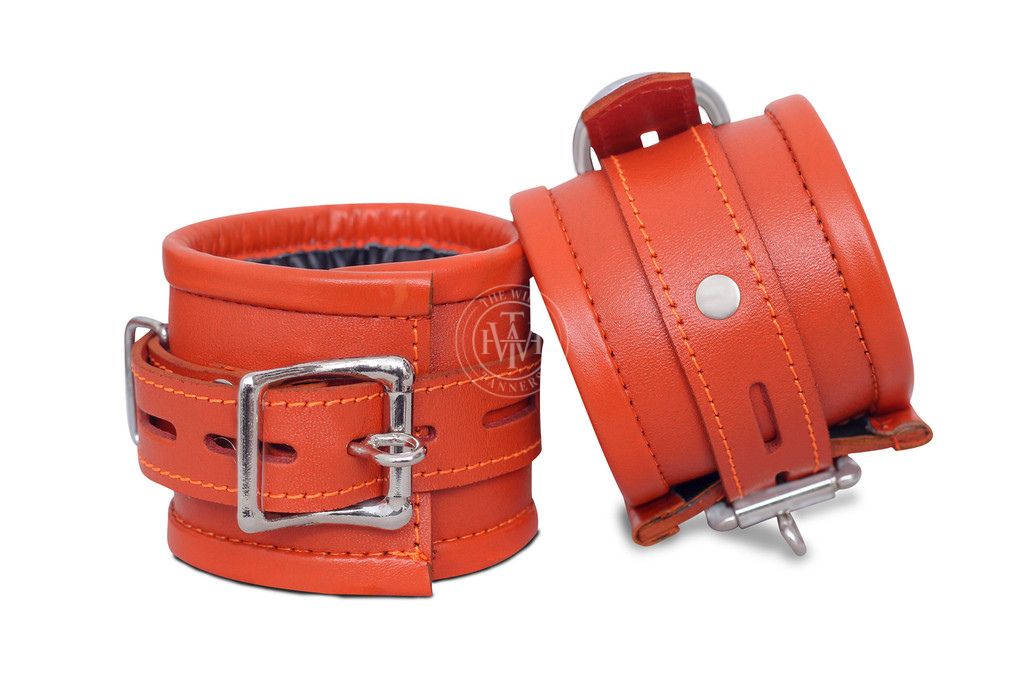 7-piece orange leather handcuffs set with adjustable straps and padded interiors